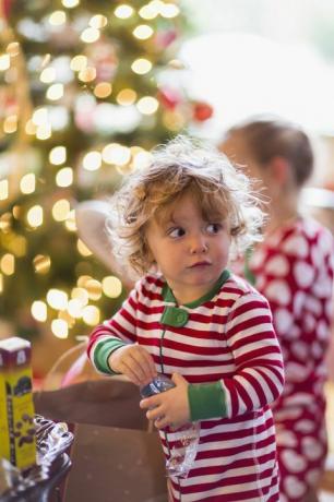 kaukázusi kisfiú megnyitása jelen a karácsonyfa közelében